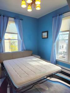 um quarto azul com uma cama e duas janelas em Island View House BnB Self Check-In em Portland