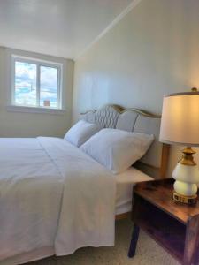 ein Schlafzimmer mit einem Bett und einem Tisch mit einer Lampe in der Unterkunft Island View House BnB Self Check-In in Portland