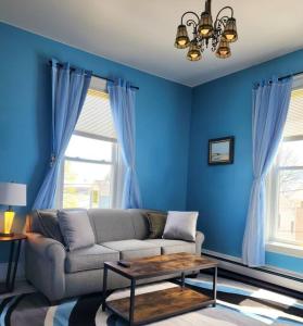 a living room with a couch and blue walls at Island View House BnB Self Check-In in Portland