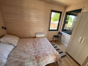 a small room with a bed and a window at Domki Letniskowe Rewa in Rewa