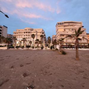 a large building with palm trees in front of it at holiday house in Durrës