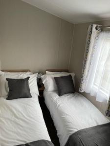 two twin beds in a room with a window at The Lookout-Ribble Valley. Amazing home Gisburn in Gisburn