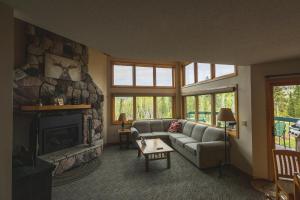 sala de estar con sofá y chimenea en Caribou Highlands Lodge en Lutsen
