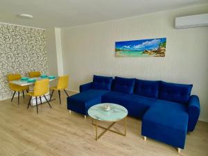 a living room with a blue couch and a table at AVRORA in Varna City