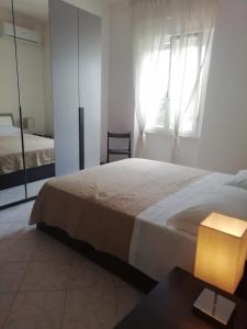 Un dormitorio con una cama grande y una ventana en Casa Clara Oristano centro con giardino en Oristano