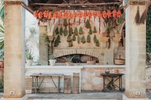 Masseria Le Lamie في Villa Castelli: مذبح خارجي بالنباتات متدلية من جدار حجري