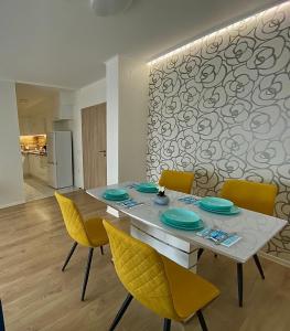 a dining room with a table and yellow chairs at AVRORA in Varna City
