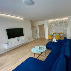 a living room with a blue couch and a flat screen tv at AVRORA in Varna City