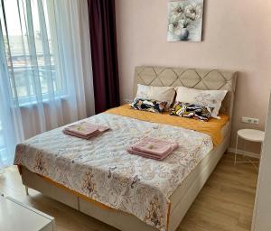 a bedroom with a bed with two towels on it at AVRORA in Varna City