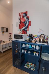 eine Küche mit einer Mikrowelle und ein Wandgemälde in der Unterkunft Mole Adriana Guest House in Rom