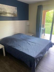 a bedroom with a bed with a blue cover on it at Studio meublé in Arles