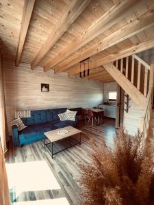 a living room with a blue couch and a table at BALTICO Domki Letniskowe in Sarbinowo