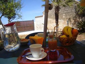 - une table avec un plateau de fruits et de boissons dans l'établissement Baglio Messina Vacanze, à Custonaci