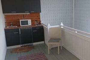 a small kitchen with a sink and a microwave at Salonsaaren Pappila in Terälahti