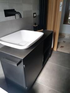 ein Badezimmer mit einem weißen Waschbecken auf einer schwarzen Theke in der Unterkunft La casa dell' Agave in Caltanissetta