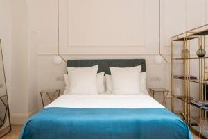 - un lit avec une couverture bleue et des oreillers blancs dans l'établissement LA SCALA SUITE-Luxury Apartment, à Milan