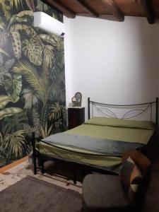 a bedroom with a bed and a chair with a mural at La casa dell' Agave in Caltanissetta