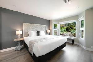Un dormitorio con una gran cama blanca y una ventana en High Point Guesthouse - Next to Seattle Chinese Garden en Seattle