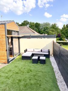 a backyard with a couch and some grass at tiny house in Cholet
