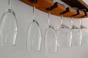 a group of glass wine glasses hanging from a rack at Modern and Private Guesthouse with Hot Tub located 500m to Havelock North Village in Havelock North