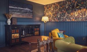 a living room with a couch and a table at Ullinish House in Ullinish