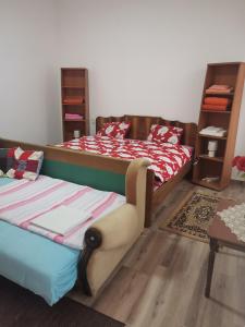 Un dormitorio con 2 camas y una silla. en T.I.M. en Bela Crkva
