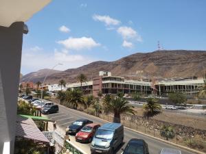 a view of a street with cars parked on the road at Acogedoras Habitaciones Privadas zona Costera Wifi in Morro del Jable