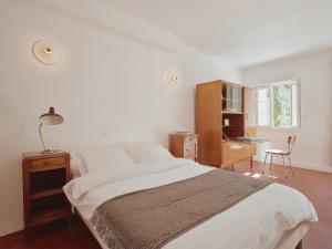 a bedroom with a bed and a desk and a window at La Boule d'Or - Auberge créative in Clamecy