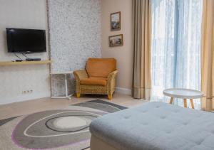 een kamer met een bed, een stoel en een televisie bij Villa Aurora in Petrovac na Moru
