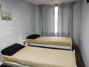 2 camas en una habitación pequeña con ventana en Duplex Olavarría en Olavarría
