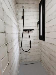 a shower with a hose attached to a wall at La Morica in Gelsa