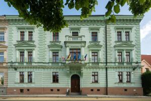 比尔森Riverside Hotel Plzeň的一座白色的大建筑,上面有旗帜