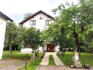 a white house with trees in front of it at Vila Gardenia in Sarajevo