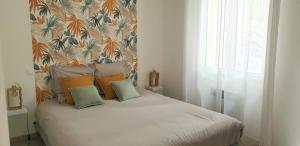 1 dormitorio con cama con almohadas y papel pintado en Une maison en Provence, en Pierrevert
