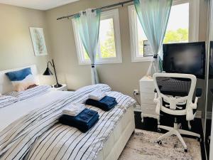 a bedroom with a bed and a chair and a television at Luxury homestay in Mississauga near square one mall & Pearson Airport in Mississauga