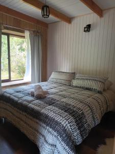 a bedroom with a large bed with a stuffed animal on it at Ruca del Fuy in Panguipulli
