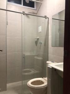 a bathroom with a toilet and a glass shower at APARTAMENTOS SUPER PENTHOUSE con ZONA BBQ in El Colegio