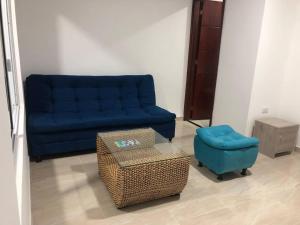 a living room with a blue couch and a ottoman at APARTAMENTOS SUPER PENTHOUSE con ZONA BBQ in El Colegio