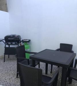 a room with black tables and chairs and a green bottle at APARTAMENTOS SUPER PENTHOUSE con ZONA BBQ in El Colegio