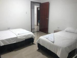 a bedroom with two beds and a mirror at APARTAMENTOS SUPER PENTHOUSE con ZONA BBQ in El Colegio