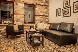 a living room with a leather couch and a table at ΣΟΧΟΣ ΠΑΡΑΔΟΣΙΑΚΕΣ ΟΙΚΙΕΣ in Zokhós