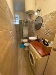 uma casa de banho com 2 WC, um lavatório e um espelho. em In The Heart Of Naples em Nápoles