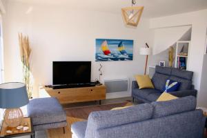 sala de estar con 2 sofás y TV en Cap à l'Ouest, en La Turballe