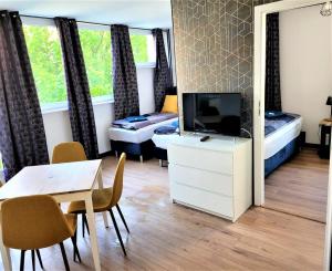 a room with a tv and a table and a bed at Szczecin Centrum 3 in Szczecin