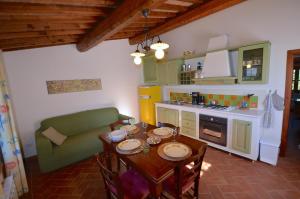 una cucina con tavolo e divano in una camera di CASE&COLLINE Gelsomino a Montescudaio