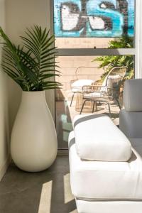 a white vase with a plant in a living room at 1500 Sq foot, 3 bed room loft in DTLA (Pool & Hot tub!) in Los Angeles