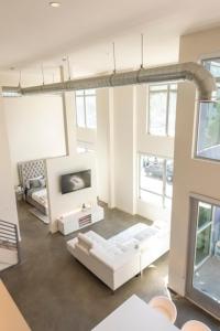 ロサンゼルスにある1500 Sq foot, 3 bed room loft in DTLA (Pool & Hot tub!)のリビングルーム(白いソファ、テレビ付)