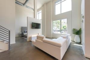 a living room with a white couch and a tv at 1500 Sq foot, 3 bed room loft in DTLA (Pool & Hot tub!) in Los Angeles