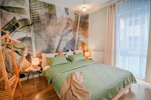 een slaapkamer met een bed met een groot schilderij aan de muur bij Apartamenty Warzywna in Leszno