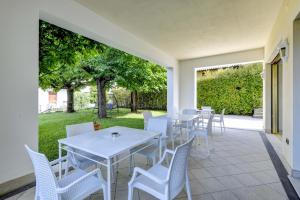 un patio con mesas blancas y sillas blancas en Hotel Mauro, en Sirmione